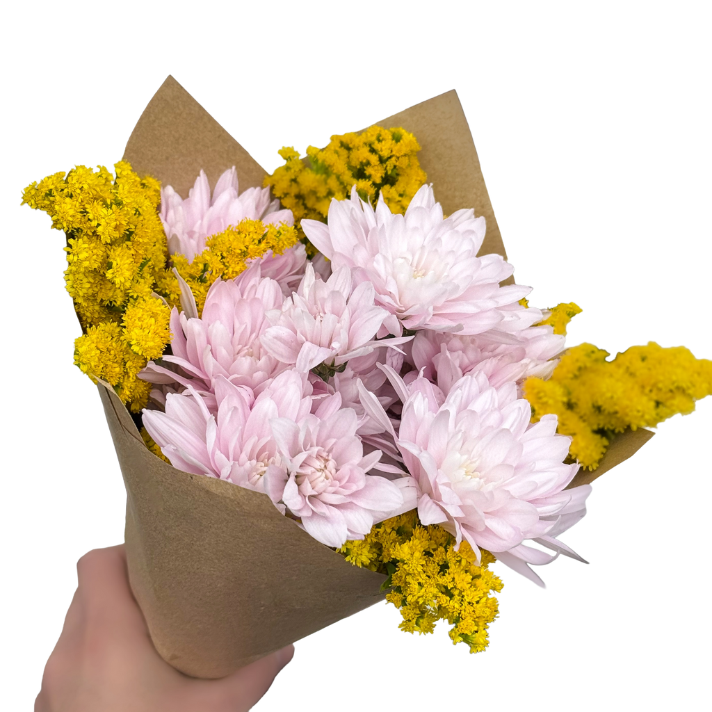 Bouquet of pink and yellow flowers wrapped in brown paper held by a hand on a white background